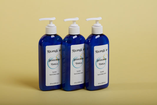 A photo of 3, 8-fluid ounce blue lotion bottles with white pumps on a yellow background labelend KalamaSoap Sandalwood Vanilla Scented Hand & Body Lotion