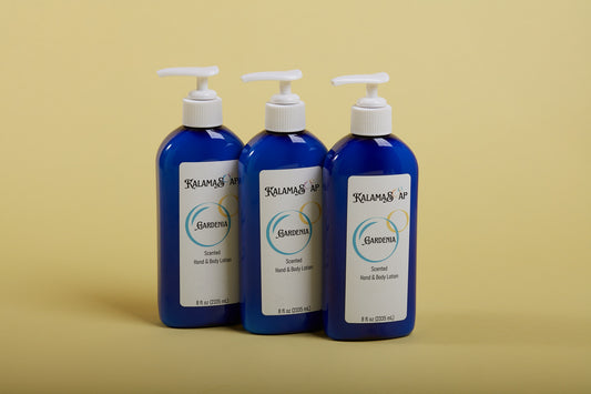A photo of 3, 8-fluid ounce blue lotion bottles with white pumps on a yellow background labelend KalamaSoap Gardenia Scented Hand & Body Lotion