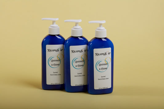 A photo of 3, 8-fluid ounce blue lotion bottles with white pumps on a yellow background labelend KalamaSoap Lavender & Cedar Scented Hand & Body Lotion